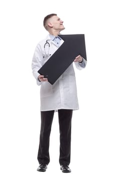 in full growth.smiling young doctor pointing in the right direction. isolated on a white background.