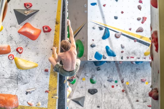 young man on a boulder climbing wall. High quality photo