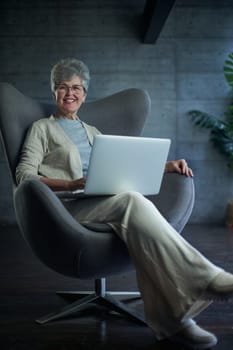 woman sitting in a chair in Art Nouveau style. Business, elegant businesswoman working on laptop . Interior, furniture.
