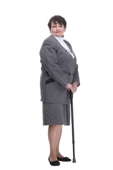 in full growth. confident old woman with a walking stick. isolated on a white background.
