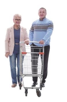 in full growth. happy married couple with shopping cart. isolated on a white background