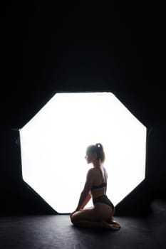 Silhouette of beautiful young woman wearing underwear in backlight