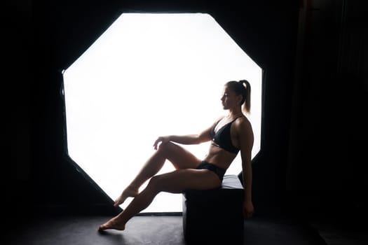 Silhouette of beautiful young woman wearing underwear in backlight