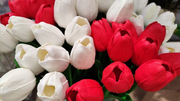 Tulips in a large bouquet. Mixed flowers background. Red and white colors of mixed flower backdrop. Texture with flowers and colour