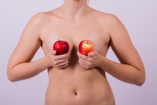 Beautiful naked woman with apples looking at the camera, with open hands