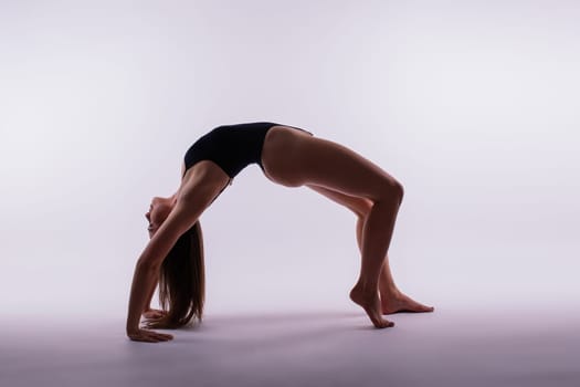 Athletic woman in swimsuit, doing yoga, push-ups, beautiful female exercising at a studio