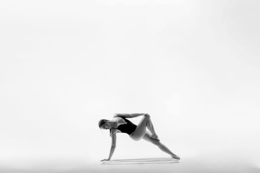 Athletic woman in swimsuit, doing yoga, push-ups, beautiful female exercising at a studio