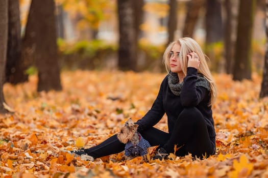 girl with her little dog in autumn park