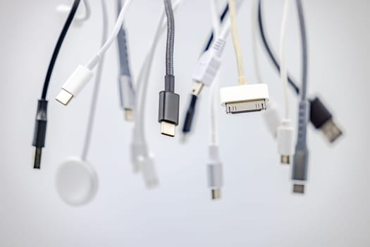 Various USB connectors and cables cropped with selective focus against white background as studio shot