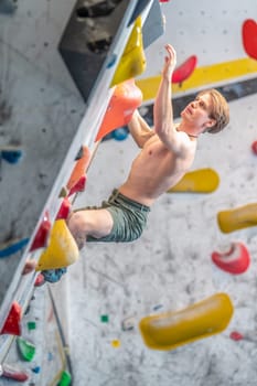 young man on a boulder climbing wall. High quality photo