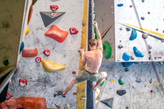 young man on a boulder climbing wall. High quality photo