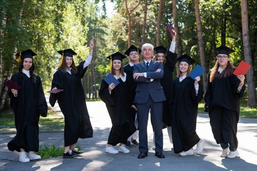 A university professor and seven robed graduates are jumping outdoors