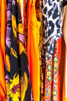 Colorful women clothes and dresses on hangers in closet in Playa del Carmen Quintana Roo Mexico.