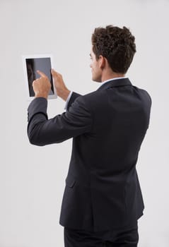 Technology is the only way forward. Rearview shot of a businessman using a digital tablet