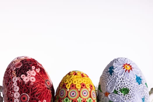 A masterpiece of handmade Easter eggs can be seen on a uniform clean background. Ornaments in honor of the Christian holiday.