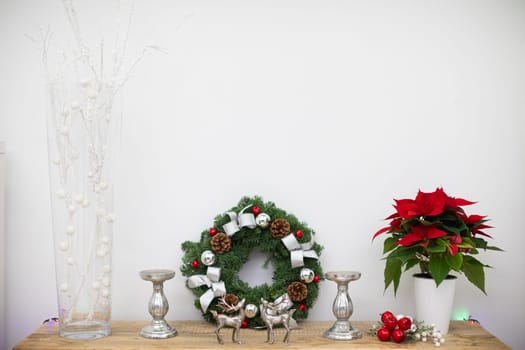 Decorations on wooden shelf. Christams girland with pinecone and silver ribbons.