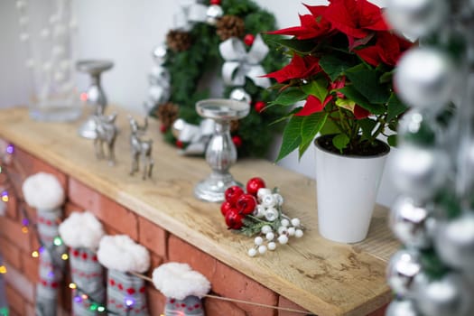 Fireplace with wooden board and winter socks. Christmas decoration on fireplace made of bricks.