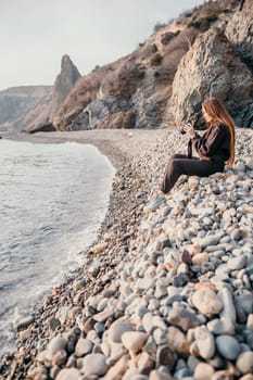 Woman travel sea. Happy tourist taking picture outdoors for memories. Woman traveler looks at the edge of the cliff on the sea bay of mountains, sharing travel adventure journey.