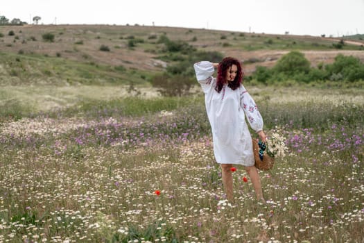 Chamomile woman. Happy curly woman in a chamomile field, dressed in a white dress