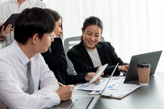 Harmony in office concept as business people analyzing dashboard paper together in workplace. Young colleagues give ideas at manager desk for discussion or strategy planning about project.