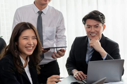 Harmony in office concept as business people analyzing dashboard paper together in workplace. Young colleagues give ideas at manager desk for discussion or strategy planning about project.