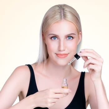 Personable portrait of beautiful woman applying extracted cannabis oil bottle for skincare product. CBD oil dropper pipette for cosmetology treatment and cannabinoids concept in isolated background.