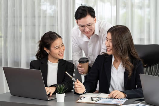 Harmony in office concept as business people analyzing dashboard paper together in workplace. Young colleagues give ideas at manager desk for discussion or strategy planning about project.