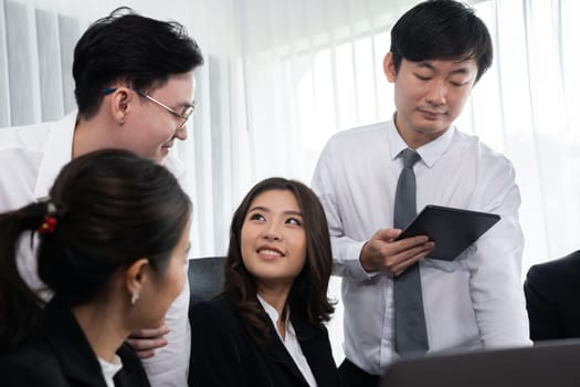 Harmony in office concept as business people analyzing dashboard paper together in workplace. Young colleagues give ideas at manager desk for discussion or strategy planning about project.