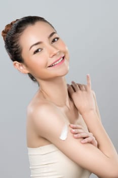 Glamorous beautiful woman applying moisturizer cream on her arm for perfect skincare treatment in isolated background. Soft makeup young girl portrait with skin rejuvenation and cosmetology concept.