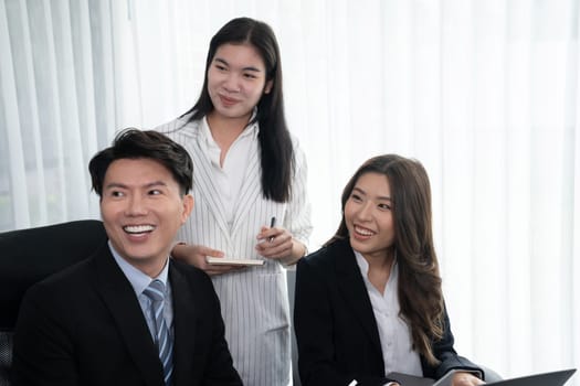 Harmony in office concept as business people analyzing dashboard paper together in workplace. Young colleagues give ideas at manager desk for discussion or strategy planning about project.