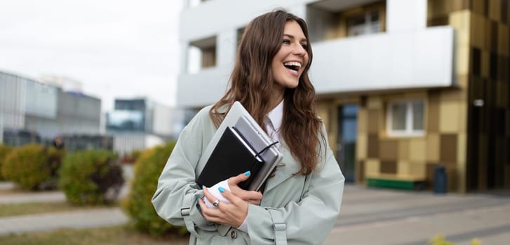 stylish young woman architect with documents in her hands on the background of a freshly built building.