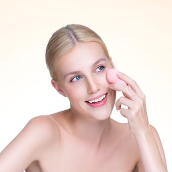 Personable beautiful natural soft makeup woman using powder puff for facial makeup concept. Cushion foundation applying on young girl face in isolated background.