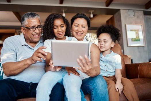 Relax, family and girls with tablet on sofa in home living room for social media or funny video streaming. Technology, care or happy grandfather, grandma and kids laughing or bonding with touchscreen.