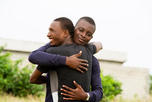 Young people standing in the air hug each other to congratulate each other smiling.