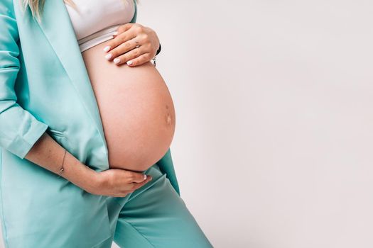 pregnant woman in a suit close-up on a gray background.