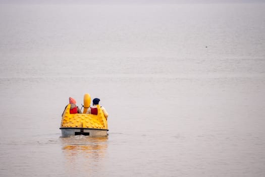 people enjoying a pedal boat decorated beautifully on the landmark sukhna lake in chandigarh with more boats in the distance showing this popular tourist spot