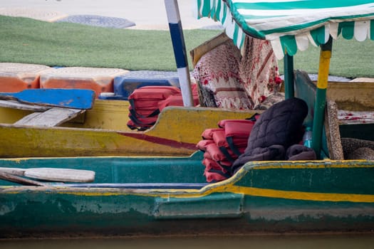 life jackets and cushions placed in shaded boat for tourists to ride on sukhna lake in chandigarh in summers in this tourist town