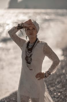 Middle aged woman looks good with blond hair, boho style in white long dress on the beach decorations on her neck and arms