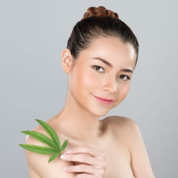 Closeup glamorous beautiful woman with soft make up and flawless smooth clean skin holding green leaf. Cannabis skincare cosmetic product for natural skin treatment concept in isolated background