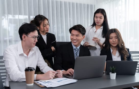 Harmony in office concept as business people analyzing dashboard paper together in workplace. Young colleagues give ideas at manager desk for discussion or strategy planning about project.