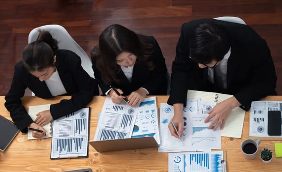 Top-view business team of financial data analysis meeting with business intelligence, report paper and dashboard on laptop for marketing strategy. Business people working together in office of harmony