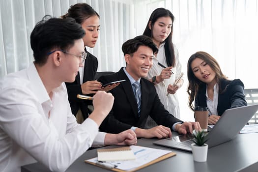 Harmony in office concept as business people analyzing dashboard paper together in workplace. Young colleagues give ideas at manager desk for discussion or strategy planning about project.