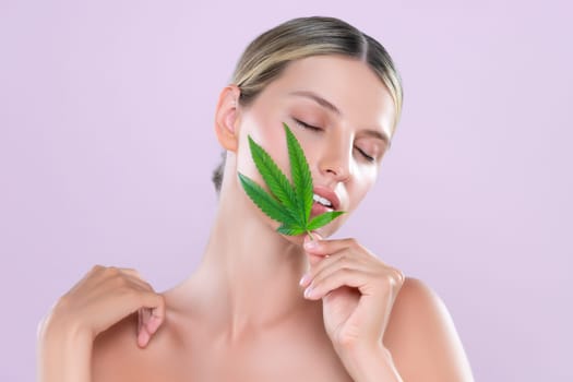 Alluring beautiful woman model portrait holding green leaf as concept for cannabis skincare cosmetic product for perfect skin freshness treatment in isolated pink background.