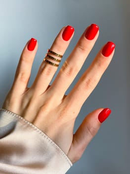 Beautiful nails manicure photo. Red color top nail polish. Female hand, rings, closeup photo, aesthetics. Manicure design, square nail shape. Luxury style, Creative beauty photo, Woman hand. High quality photo. High quality photo