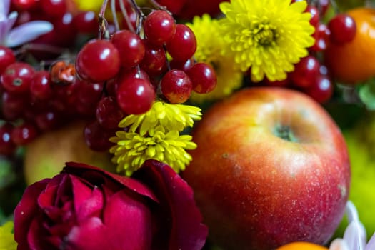 Delicious autumn still life. Apple, viburnum and flowers close-up.