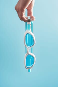 White swimming goggles on a blue background in a minimalist style with free space