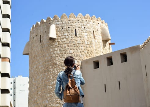 Woman tourist with a backpack on the Arab streets in the old part of Sharjah, UAE