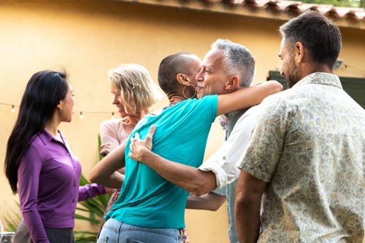 Friends arriving to garden dinner party. Hosts welcoming guests. Lifestyle concept.