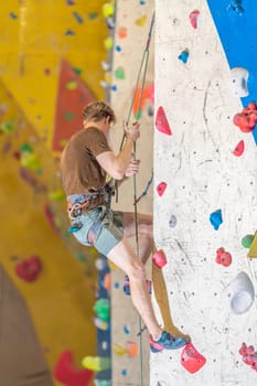 climber with safety rope on an artificial climbing wall. High quality photo