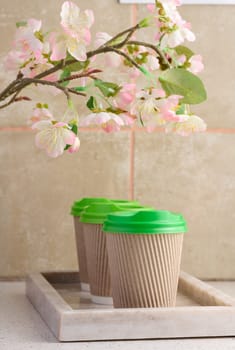 Paper brown cups with a plastic green lid for coffee and tea